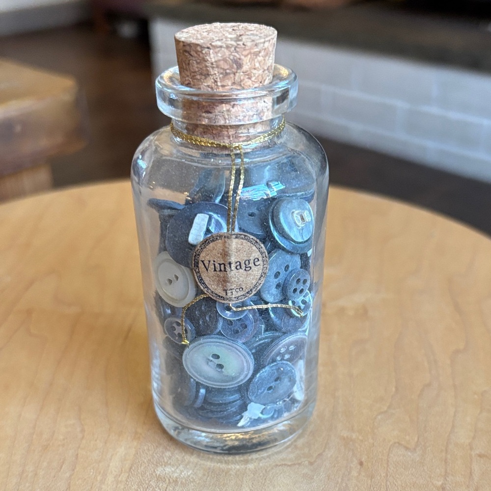 vintage glass bottle with mother of pearl buttons for sewing